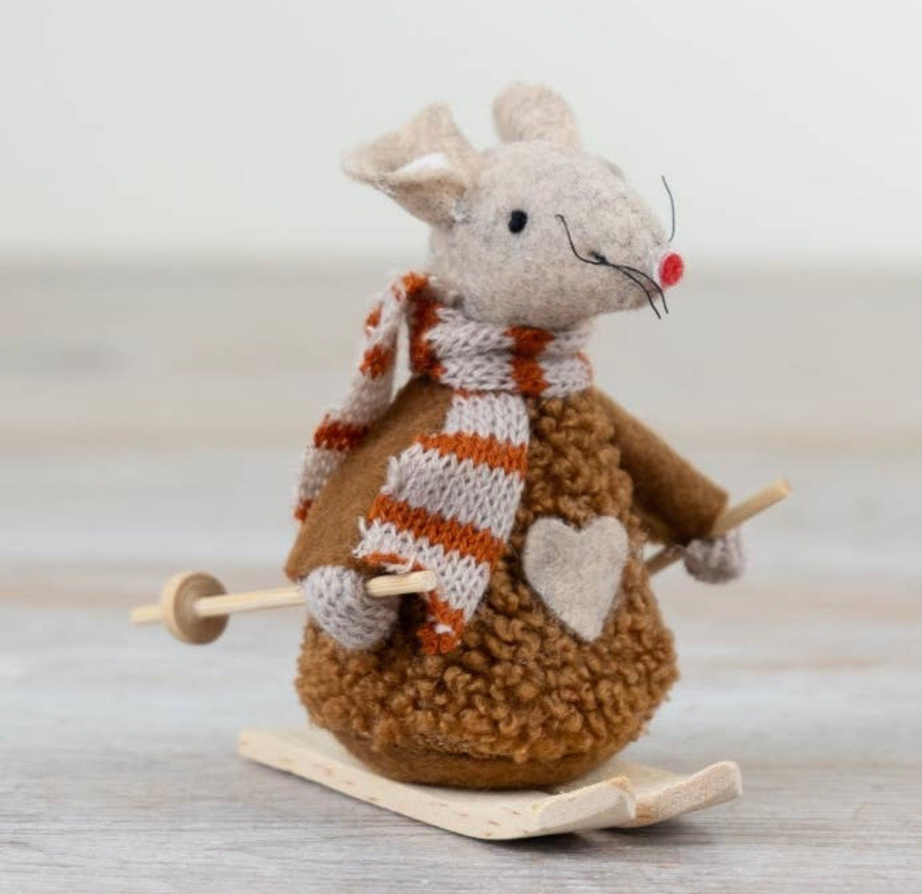 Autumn skiing mouse ornament wearing a striped scarf and standing on wooden skis with ski poles.