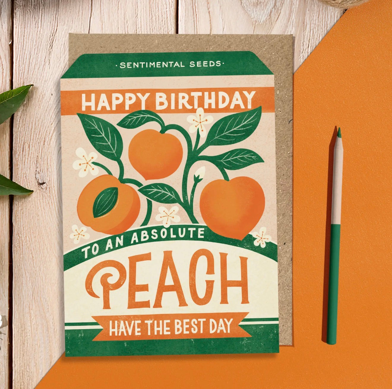 Orange and green Happy Birthday Absolute Peach sentimental seeds greeting card with illustrated peaches, leaves and flowers.
