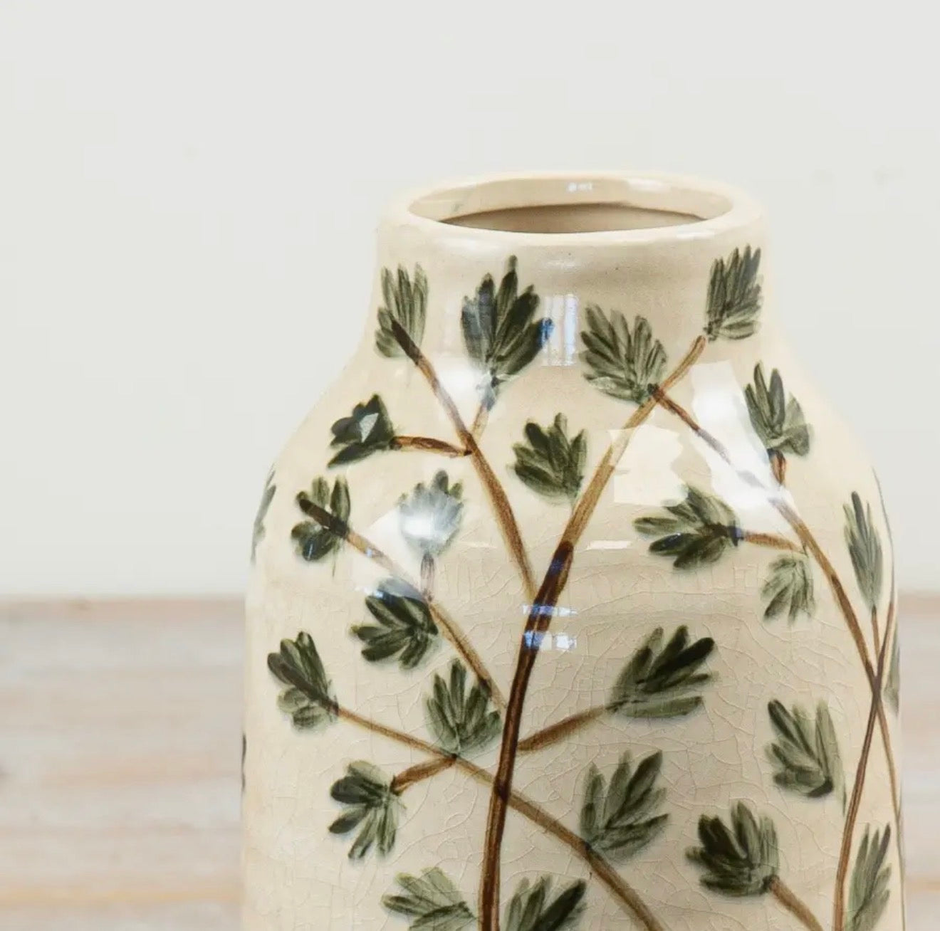 Small botanical ceramic vase with hand-painted leaf design for fresh or dried flowers.