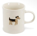Cream stoneware mug featuring a small illustrated black and tan dog on the front.