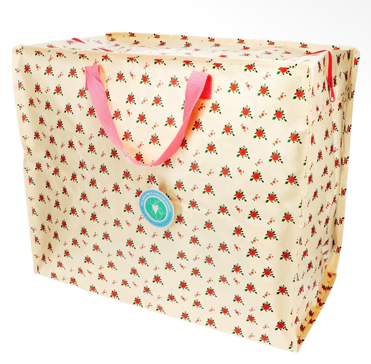 Large cream storage bag with a small red and green French rose floral print and bright pink carry handles.