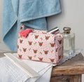 Soft pink quilted makeup bag with a red and green French rose floral print, zip fastening and pink tassel.