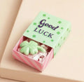Ceramic four leaf clover keepsake token presented in a colourful matchbox with the message “Good Luck”.