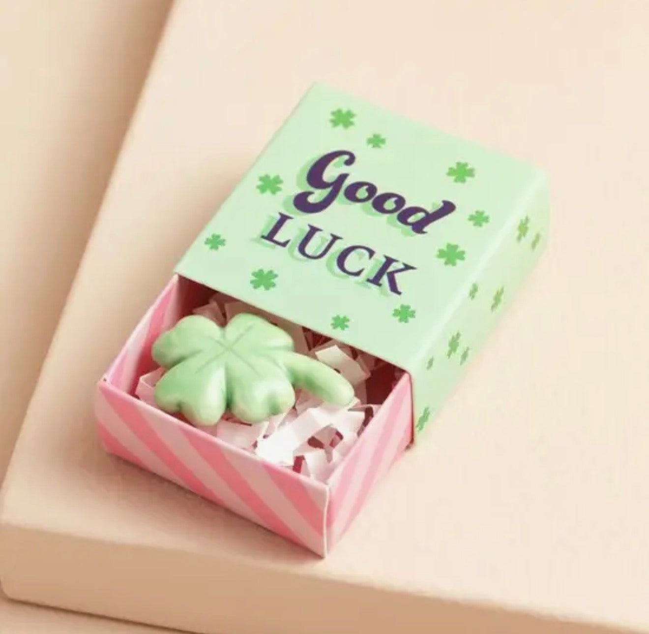 Ceramic four leaf clover keepsake token presented in a colourful matchbox with the message “Good Luck”.
