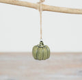 Green ceramic pumpkin hanging ornament with rustic jute string for autumn and seasonal home décor.
