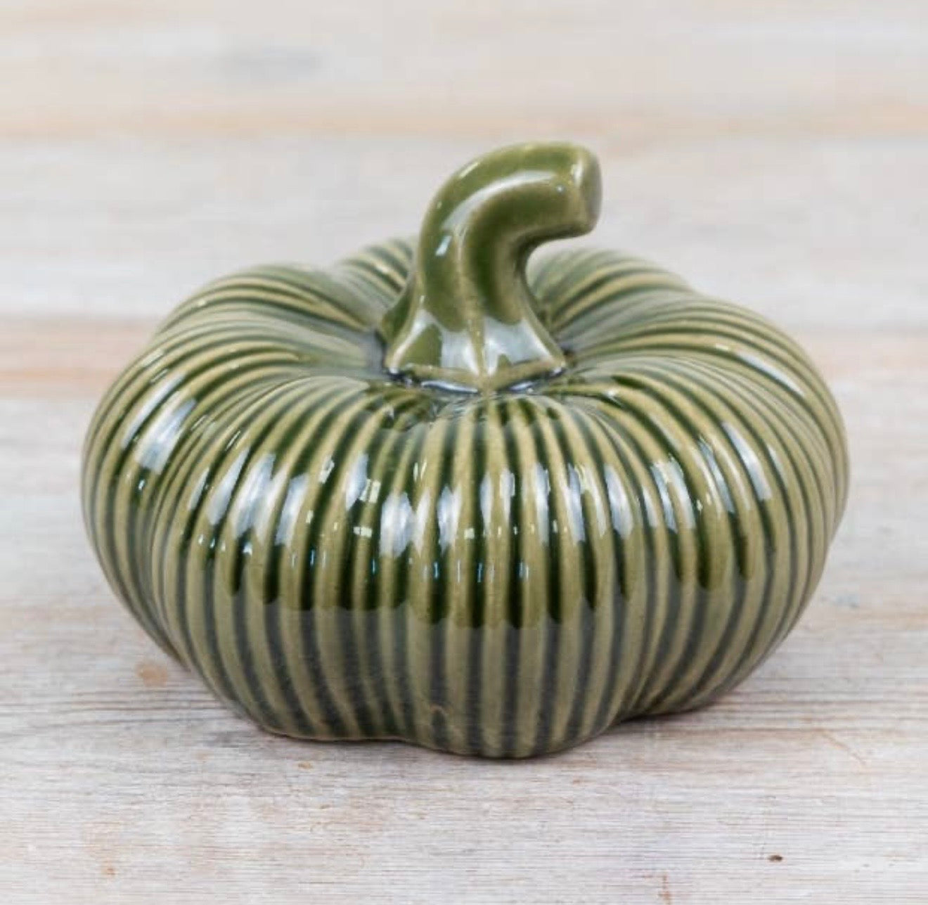 Green ribbed ceramic pumpkin ornament for autumn home décor and seasonal styling.
