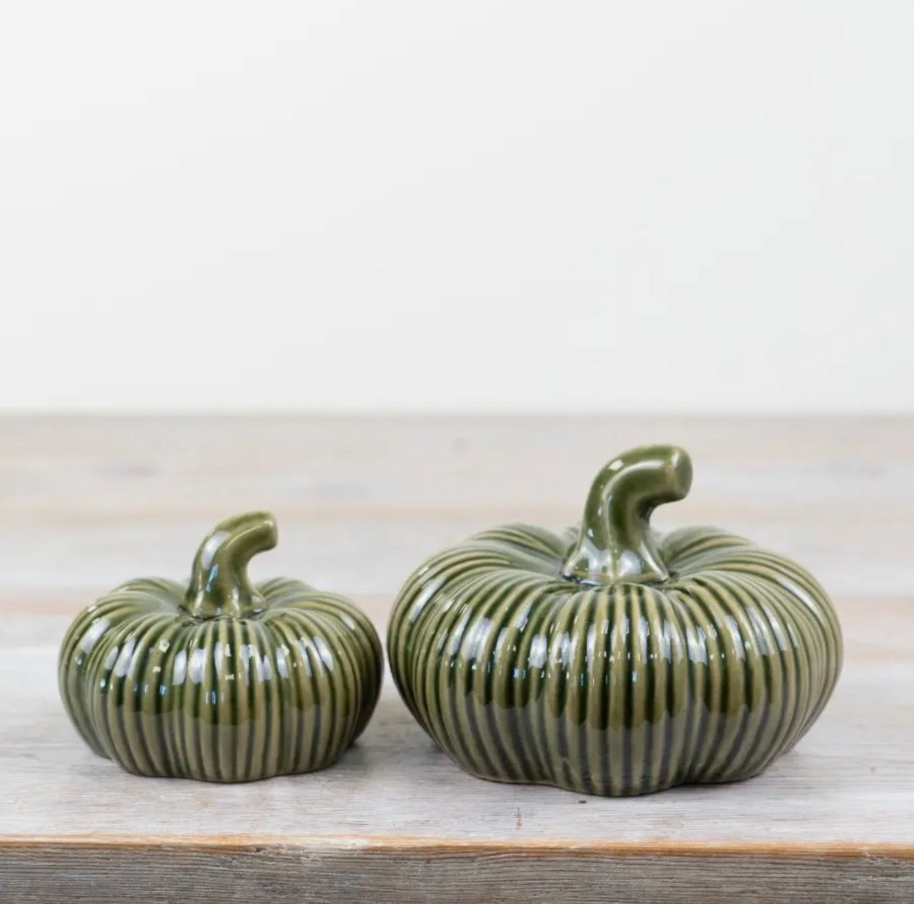 Green ribbed ceramic pumpkin ornament for autumn home décor and seasonal styling.
