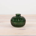 Green ribbed glass bud vase with a rounded shape, perfect for displaying single stems or dried flowers.