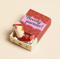 Ceramic cowboy boot keepsake token presented in a colourful matchbox with the message “Howdy Partner!”.