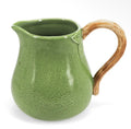 Lime green stoneware jug with a speckled finish, leaf detail and contrasting brown curved handle.