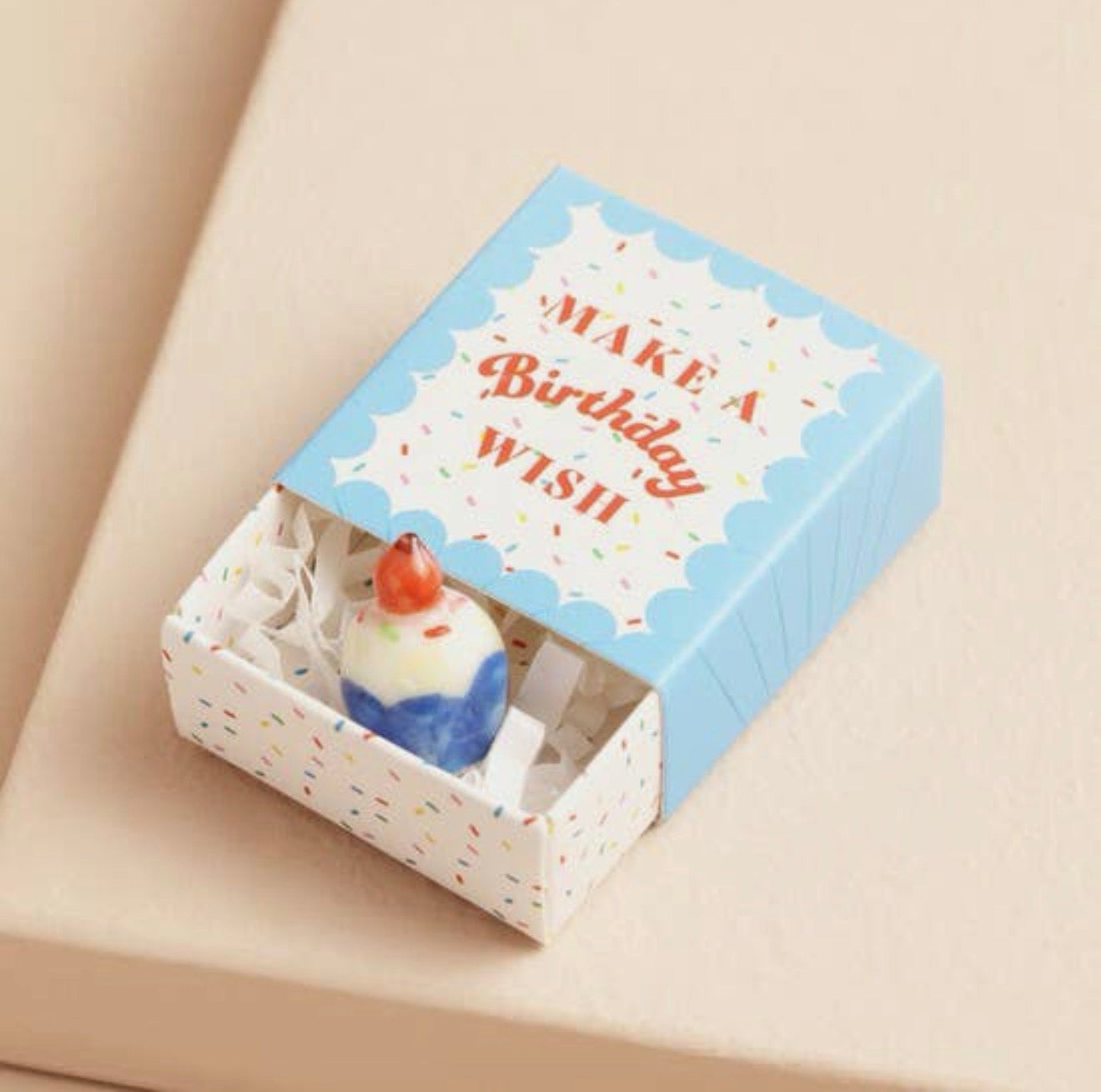 Ceramic birthday cupcake keepsake token presented in a blue matchbox with the message “Make a Birthday Wish”.
