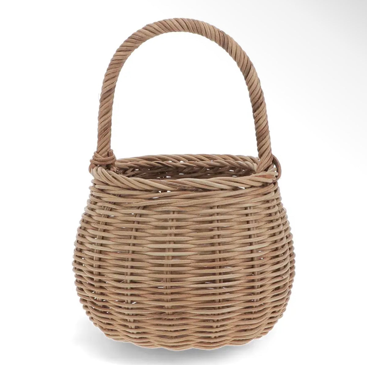 Small natural woven wicker basket with a rounded shape and tall curved carry handle.