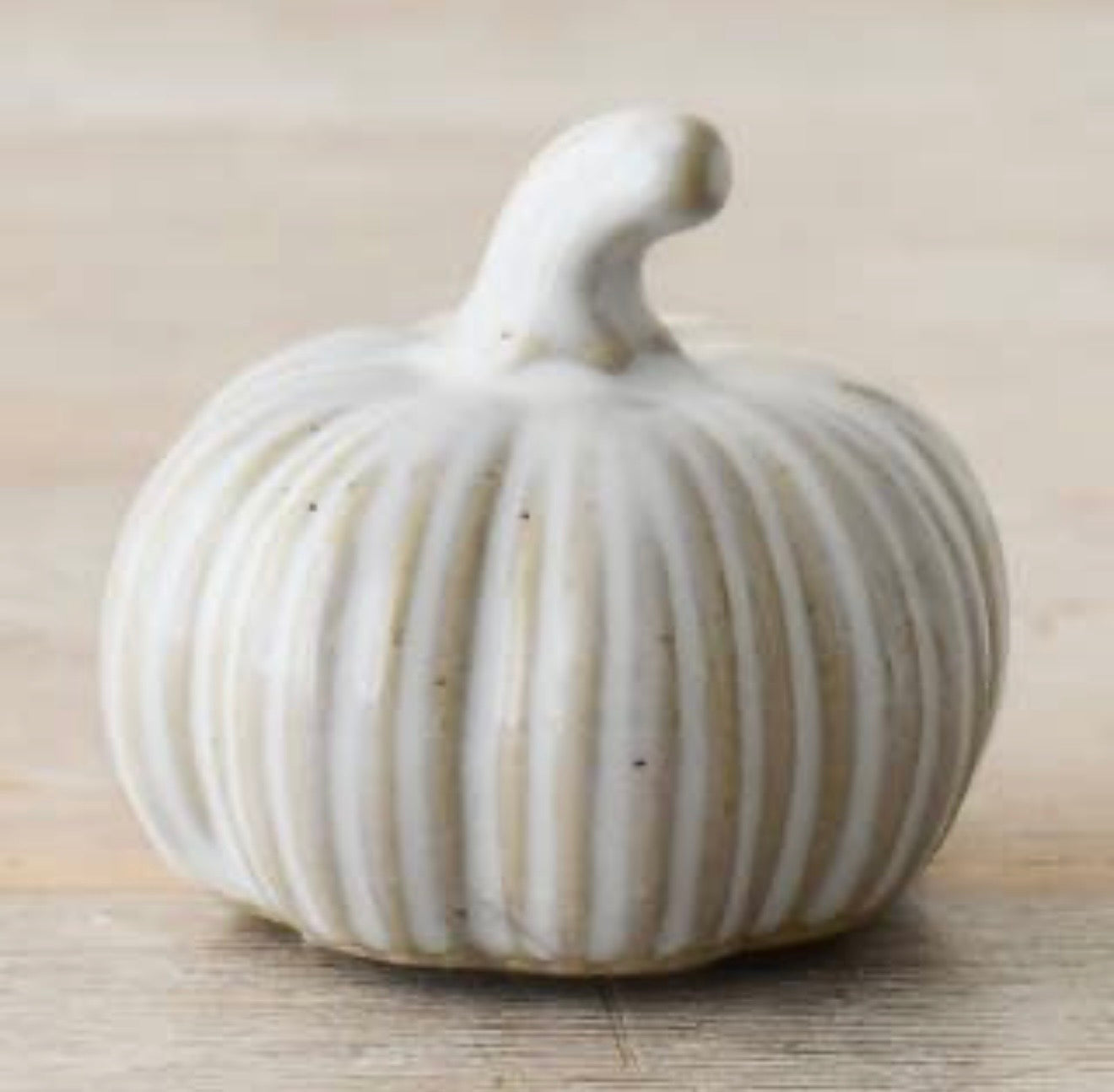 Neutral ribbed ceramic pumpkin ornament with a soft matte finish for autumn home décor and seasonal styling.