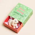 Ceramic bunny keepsake token presented in a green and coral matchbox with the message “Some Bunny Loves You”.
