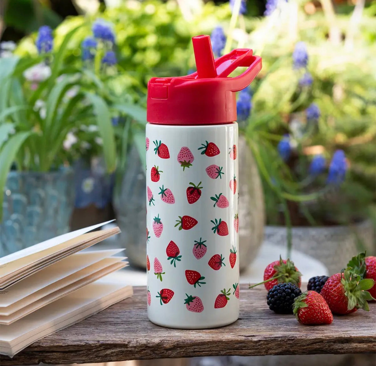 500ml cream drinks bottle decorated with red and pink strawberries and a bright red flip-top drinking lid.