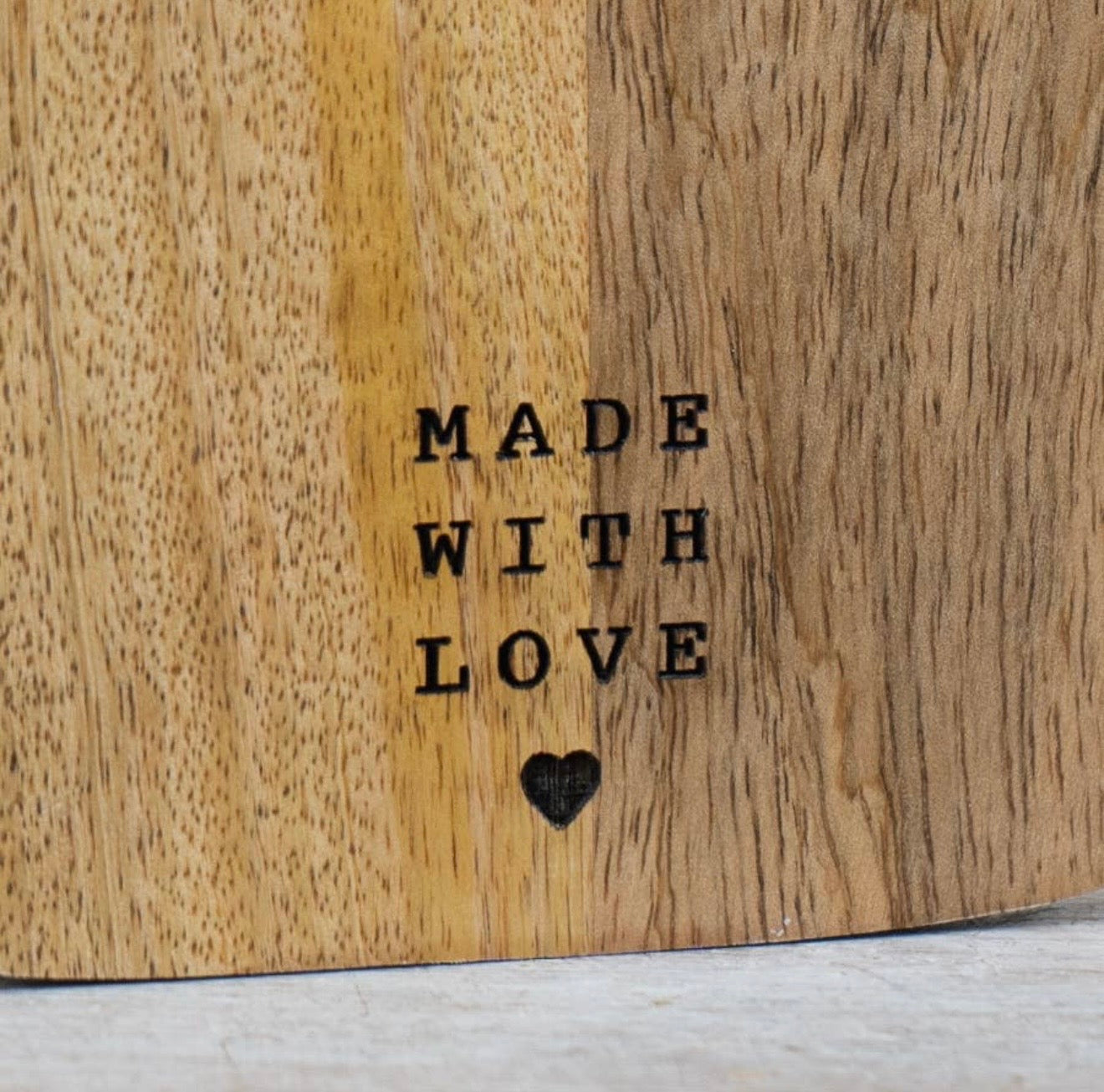 Wooden chopping and serving board with handle for food preparation, serving and kitchen styling.